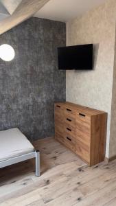 a bedroom with a bed and a tv on a wall at Apartament 4 Słoneczna in Ełk