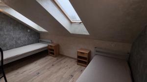 a attic room with a skylight and wooden floors at Apartament 4 Słoneczna in Ełk