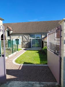 an external view of a house with a gate at Chambre sous les toits in Baule
