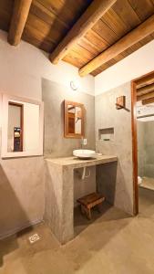 a bathroom with a sink and a wooden ceiling at Vila Alta Caraíva in Caraíva
