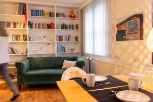a living room with a green couch and a table at Vacation, also with a dog, in Stade! in Stade