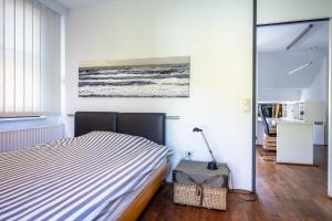 a bedroom with a bed and a painting on the wall at Vacation, also with a dog, in Stade! in Stade