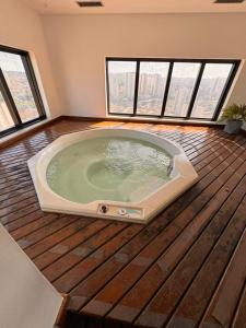 a hot tub in the middle of a room with windows at MN Gotado Hotel Flat Guarulhos Aeroporto in Guarulhos +24 photos