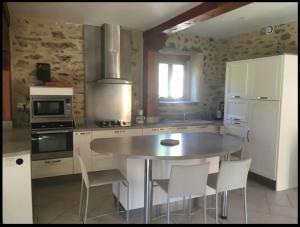a kitchen with a table and some chairs in it at Chez Baptistète in Labastide