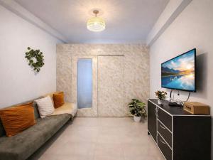 a living room with a couch and a tv at MOA staycation Shore 1 tower D in Manila +8 photos
