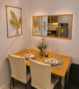 a dining room table with white chairs and a mirror at MOA staycation Shore 1 tower D in Manila