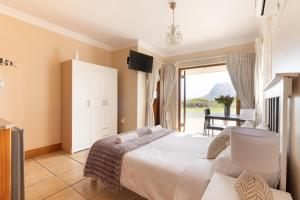 a bedroom with a bed and a sliding glass door at Coastline Serenity in Kleinmond