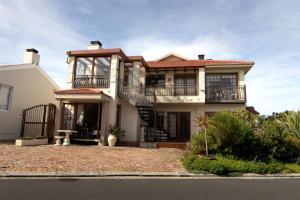 a large white house with a balcony at Coastline Serenity in Kleinmond