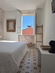 a bedroom with a bed and a large window at azul rooms & suites in Olbia