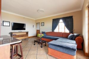 a living room with a couch and a television at Coastline Serenity in Kleinmond