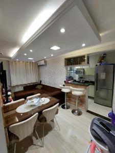 a kitchen with a table and chairs and a refrigerator at Apartamento prox Praça Nova Shopping in Araçatuba