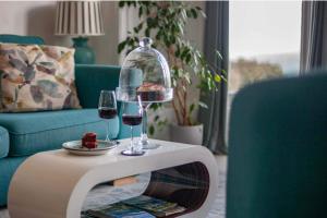a table with two glasses of wine and a plate of food at Sea View Ultimate Boutique escape! in Barnstaple