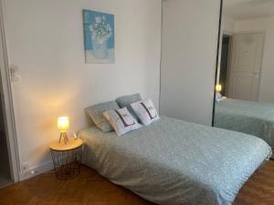 a bedroom with two beds and a lamp on a table at Maison Mylan, simple and practical! in Cholet