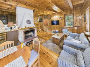 a living room with a fireplace in a log cabin at Chata na Jurze z balią in Zarki Letnisko