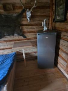 a room with a small refrigerator and horns on the wall at Chata Między Górami in Zalesie