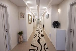 a hallway with white walls and a black and white carpet at Kafaoğlu Otel in Ereğli