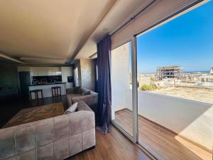 a living room with a couch and a large window at Bizerta Méditerranée in Bizerte