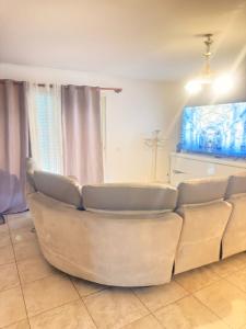 a white couch in a living room with a tv at Maison à louer in Valence