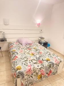 a bed with a floral comforter in a bedroom at Maison à louer in Valence