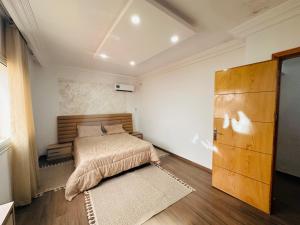 a bedroom with a bed and a large wooden door at Bizerta Méditerranée in Bizerte