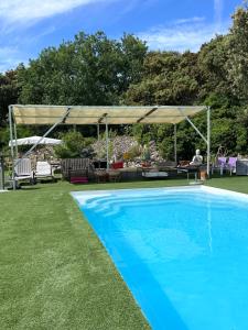 a swimming pool in a yard with a canopy over it at Chambre Le mas d'Adelice in Taulignan