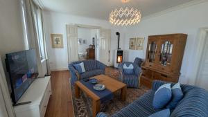 a living room with blue furniture and a tv at Ostsee Stadthus in Heiligenhafen
