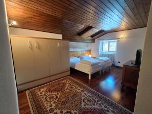 a bedroom with a bed and a wooden ceiling at B&b Villa Giò in Cremeno