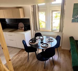 a dining room table and chairs in a room at Le Cocon du Mont'Anay in Montanay