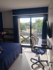 a bedroom with a desk and a chair and a window at Eco Paradise 228 in Cumbuco