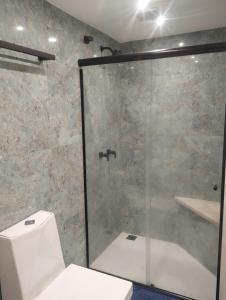 a bathroom with a glass shower with a toilet at Eco Paradise 228 in Cumbuco +10 photos
