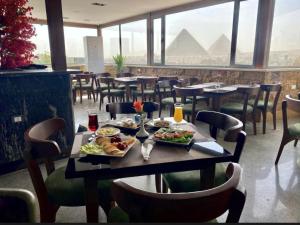 a table with food on it in a restaurant with pyramids at The Grand Delta Hotel in Cairo