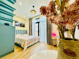 a bedroom with a bed and a vase with flowers at Myla House in Ho Chi Minh City +25 photos