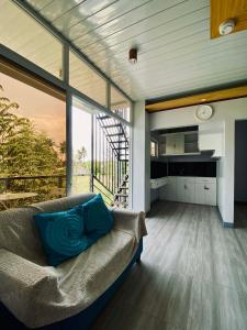 a living room with a couch and a large window at The Grey House in Bacong