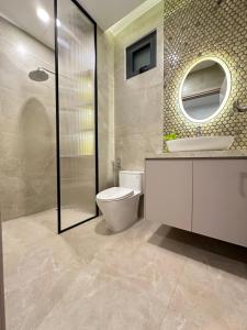 a bathroom with a toilet and a sink and a mirror at Myla House in Ho Chi Minh City
