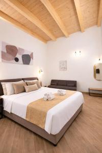 a bedroom with a large white bed with a wooden ceiling at Sicily Luxury Suites in Palermo