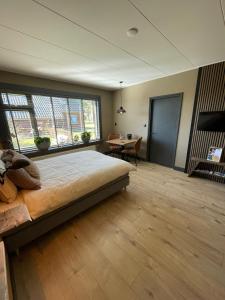 a bedroom with a large bed and a table at B&B Opoes huusie in Lutten