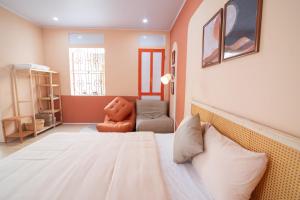 a bedroom with a large bed and a chair at An Du Boutique Stay in Dong Hoi +42 photos