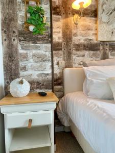 a bedroom with a bed and a nightstand next to a bed at Le Clos de la Barre - Maison de charme au calme -à 10 min des plages du Débarquement - petit-déjeuner maison in Basly