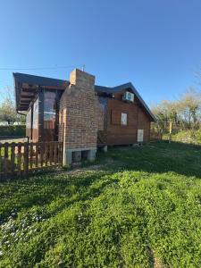 a brick house with a fence in a yard at Kuća za odmor Mia in Gornja Gračenica