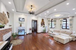 a living room with a white couch and a fireplace at Villa Thung Lũng Hồng 2 in Ấp Kim Thạch