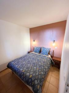 a bedroom with a bed with blue sheets and blue pillows at Séjour 4 personnes - Pays Basque in Uhart-Cize