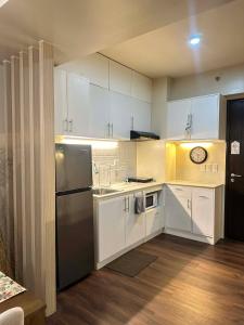 a kitchen with white cabinets and a stainless steel refrigerator at Ilo2stayAirbnb 1BR 334 in Molo