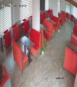 an empty waiting room with red chairs and tables at Taj Plaza in Sowayma