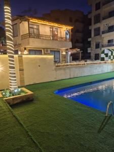 a house with a swimming pool at night at Taj Plaza in Sowayma