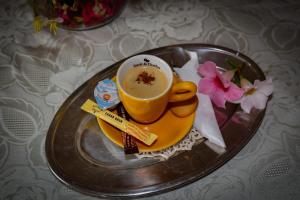 a cup of coffee on a plate on a table at Panorama Guesthouse in Sighişoara