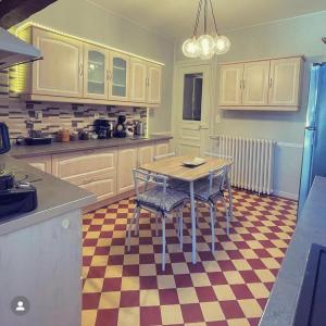 a kitchen with a table and chairs on a checkered floor at Gite L'Instant Champenois in Bréviandes