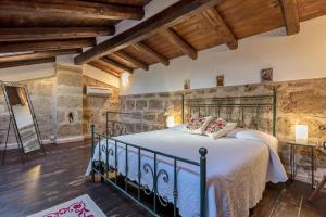 a bedroom with a large bed in a room with wooden ceilings at Emerald apartment in Alghero Historic Center in Alghero