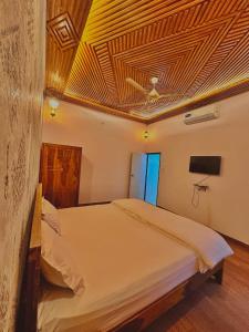 a bedroom with a large bed with a ceiling at The Kandarp Villa in Jaipur