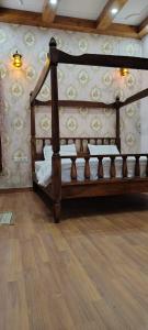a wooden bed in a room with a wall at The Kandarp Villa in Jaipur