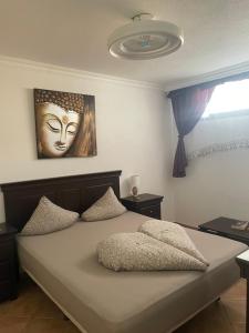 a bedroom with a bed with a mask on the wall at Apartmán Centrum in Los Cristianos +3 photos